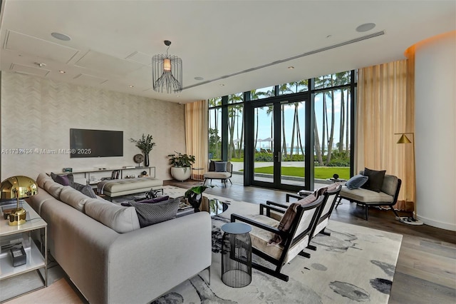 living room with expansive windows, hardwood / wood-style floors, and french doors