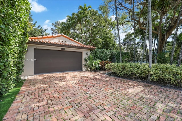 garage with decorative driveway