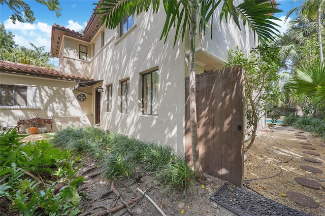 view of property exterior featuring a tile roof and stucco siding