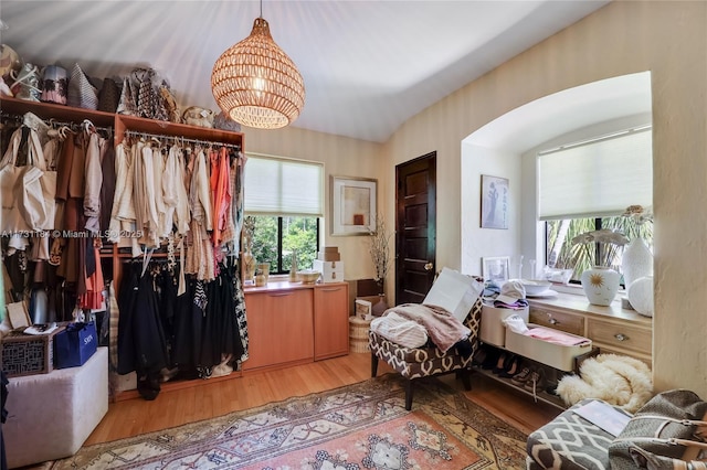 interior space with a chandelier, arched walkways, and light wood finished floors