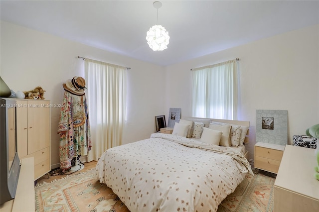 bedroom with a chandelier and light wood-style flooring