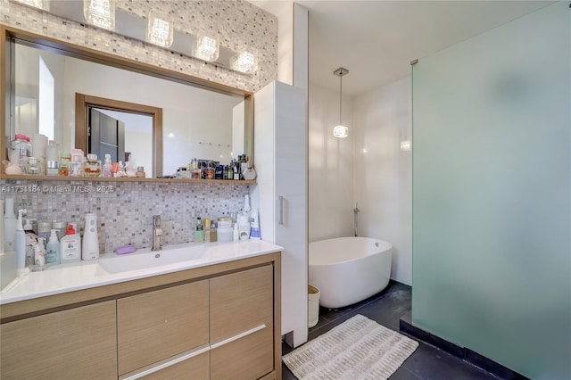 full bath with backsplash, a freestanding tub, vanity, and tile patterned floors