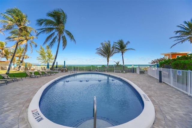 view of pool featuring a water view and a patio area