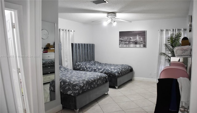 bedroom featuring ceiling fan, a textured ceiling, and light tile patterned floors