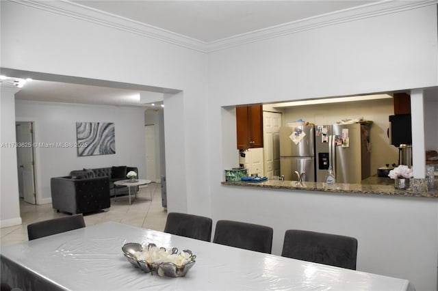 dining room with light tile patterned floors and ornamental molding