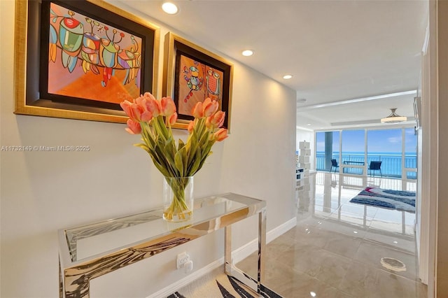 hallway featuring floor to ceiling windows and a water view