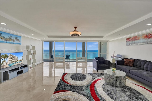 living room with crown molding, expansive windows, a raised ceiling, and a water view