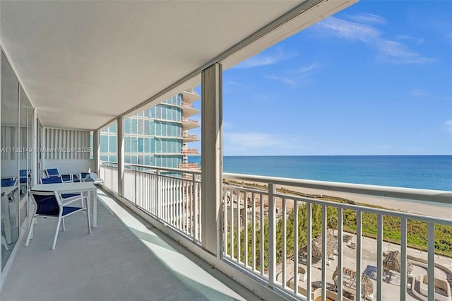 balcony featuring a view of the beach and a water view