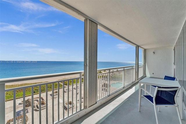 balcony featuring a beach view and a water view