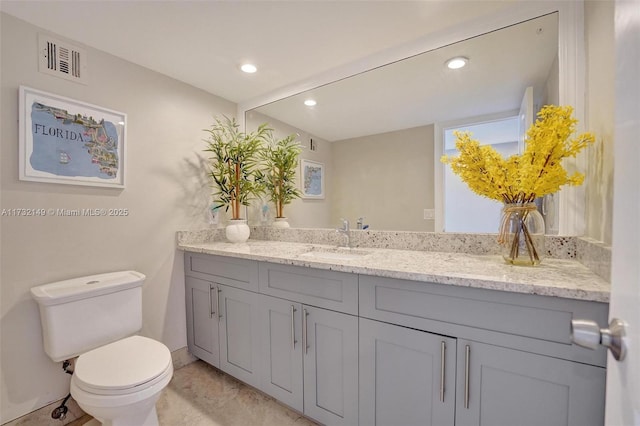 bathroom with toilet, recessed lighting, visible vents, and vanity