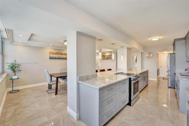 kitchen with baseboards, light stone counters, stainless steel appliances, gray cabinetry, and pendant lighting