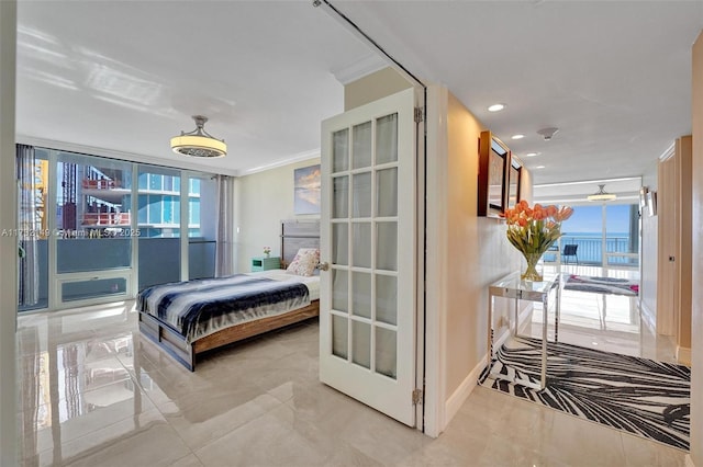 bedroom with multiple windows, a wall of windows, and crown molding