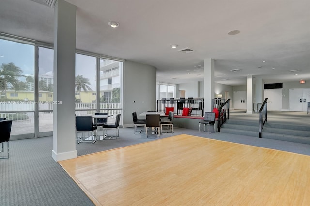 interior space featuring expansive windows, carpet floors, visible vents, and baseboards