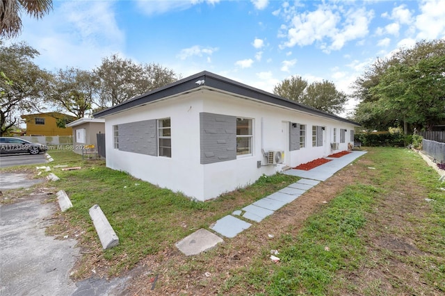 view of side of home featuring a yard and ac unit