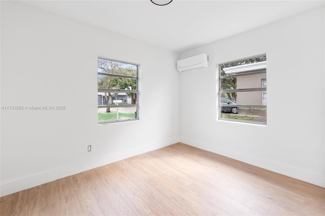 spare room with wood-type flooring and a wall mounted air conditioner