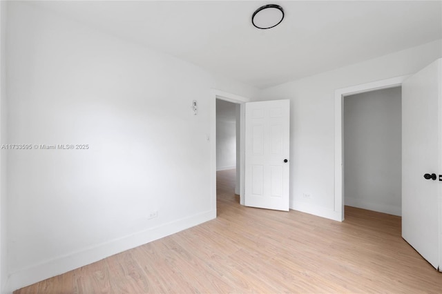 unfurnished bedroom featuring light hardwood / wood-style floors and a closet