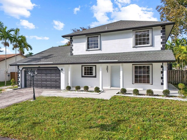 view of front property featuring a garage, a front lawn, and covered porch