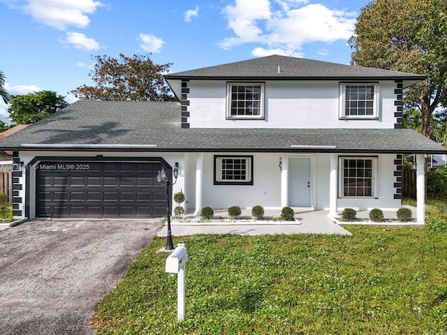 traditional-style house with a shingled roof, a front lawn, aphalt driveway, stucco siding, and an attached garage