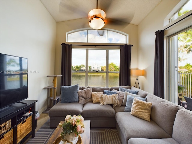 living room with a water view, a wealth of natural light, and lofted ceiling