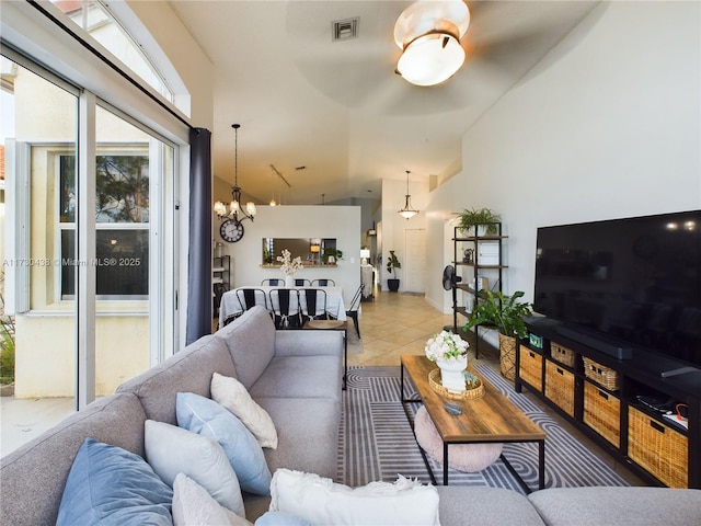 living room featuring light tile patterned flooring, lofted ceiling, and an inviting chandelier