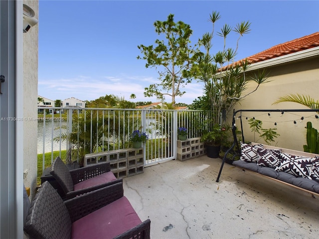 view of patio with a water view and a balcony