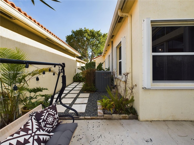 view of property exterior with cooling unit and a patio