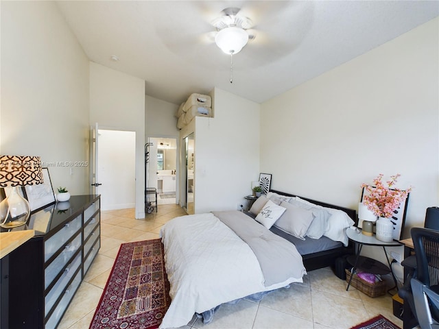 bedroom featuring ceiling fan, ensuite bath, vaulted ceiling, and light tile patterned floors