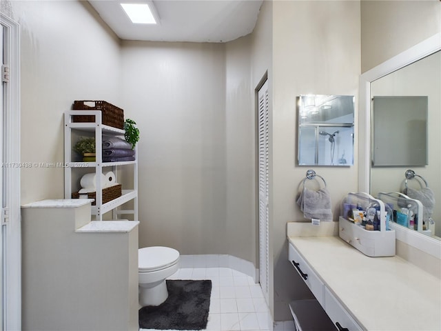 bathroom featuring vanity, a shower, tile patterned floors, and toilet