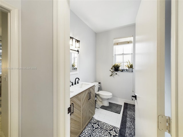 bathroom with tile patterned flooring, vanity, and toilet