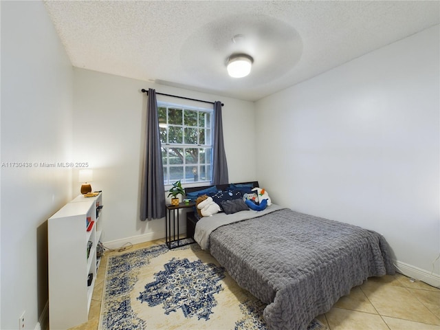 bedroom featuring a textured ceiling and light tile patterned floors