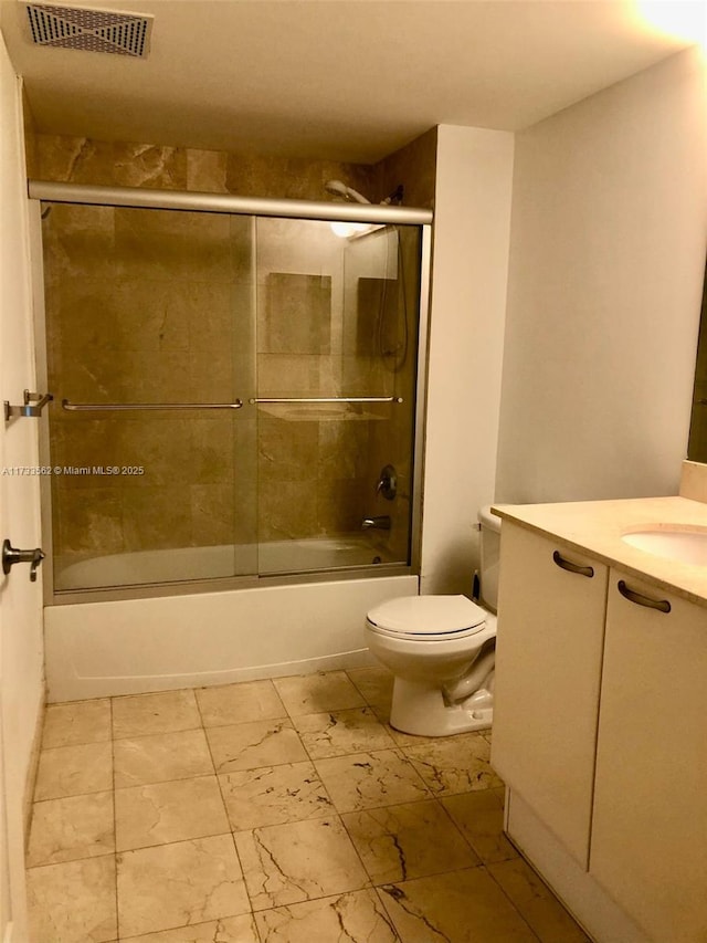 full bathroom featuring bath / shower combo with glass door, vanity, and toilet