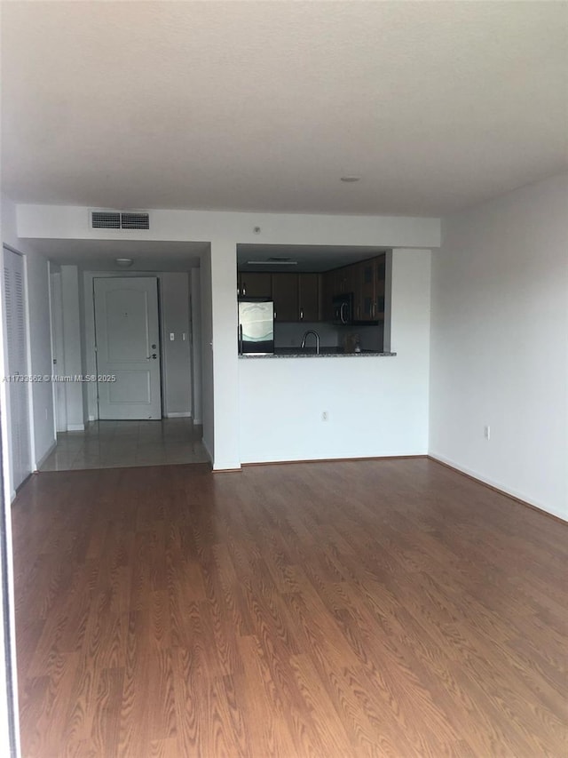 unfurnished living room with sink and dark hardwood / wood-style flooring