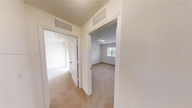 corridor featuring light colored carpet