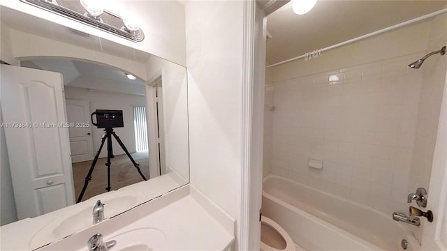 bathroom with tiled shower / bath combo and toilet