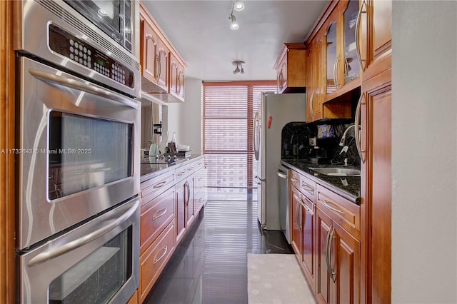 kitchen with appliances with stainless steel finishes, sink, and backsplash