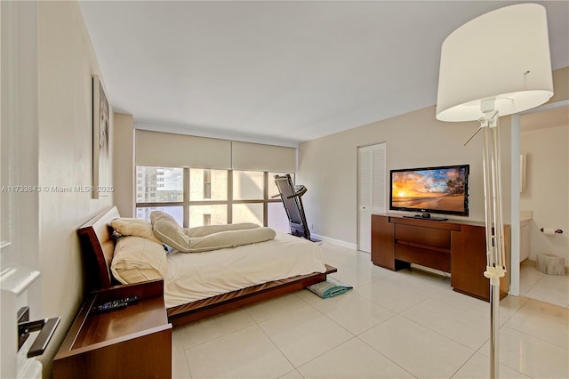 bedroom featuring ensuite bathroom and light tile patterned floors