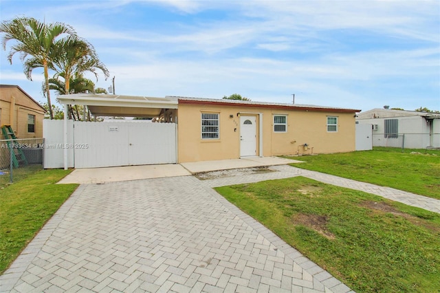 view of front of property with a front yard and a carport