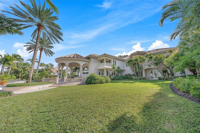 mediterranean / spanish-style home with french doors and a front lawn