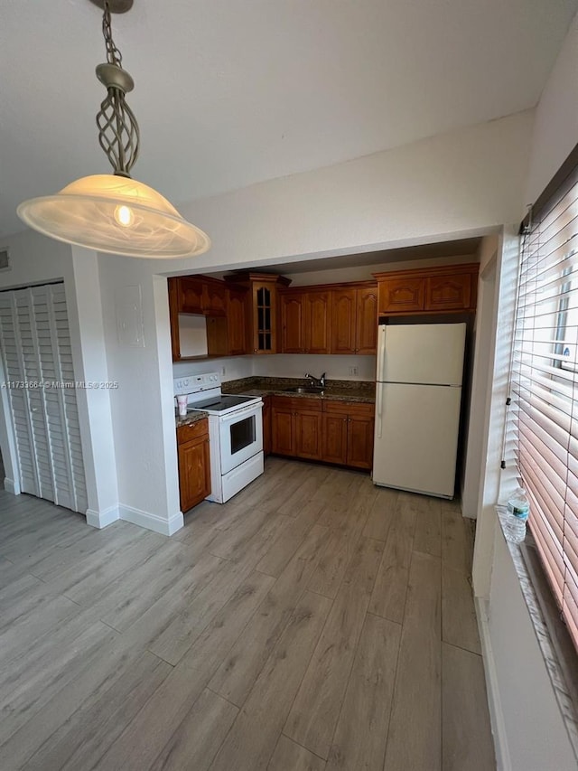 kitchen featuring pendant lighting, sink, white appliances, and light hardwood / wood-style flooring