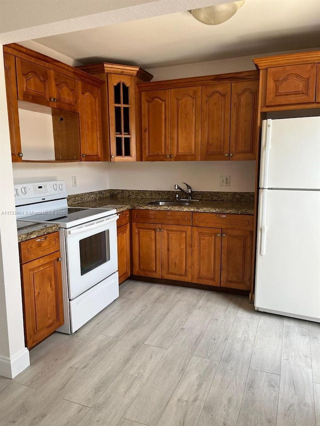 kitchen featuring white appliances, light hardwood / wood-style floors, and sink