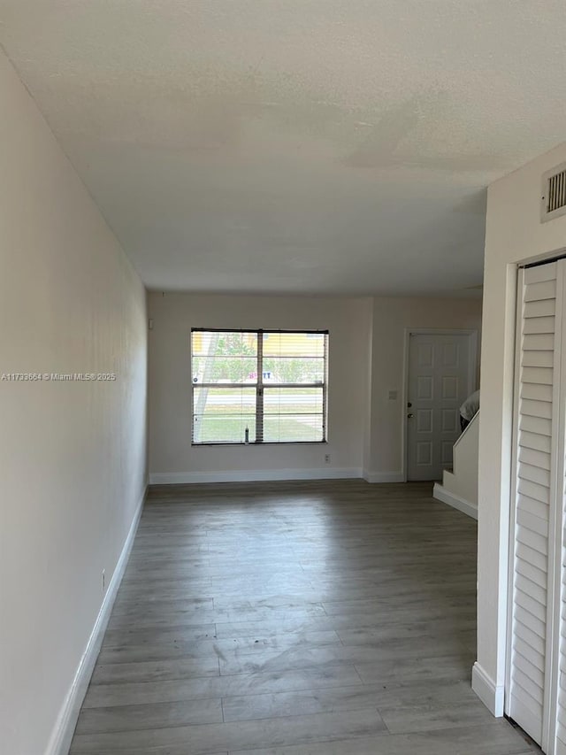 unfurnished room featuring hardwood / wood-style floors and a textured ceiling