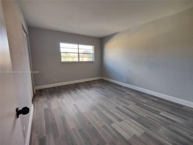 unfurnished room with dark wood-type flooring