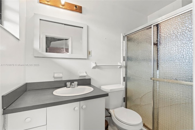 bathroom with vanity, an enclosed shower, and toilet