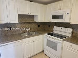 kitchen featuring sink, light tile patterned floors, white cabinets, white appliances, and backsplash