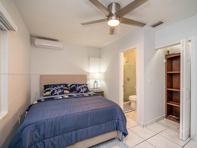 bedroom featuring ceiling fan, ensuite bath, and a wall mounted AC