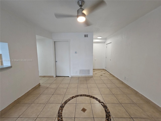 tiled empty room featuring ceiling fan