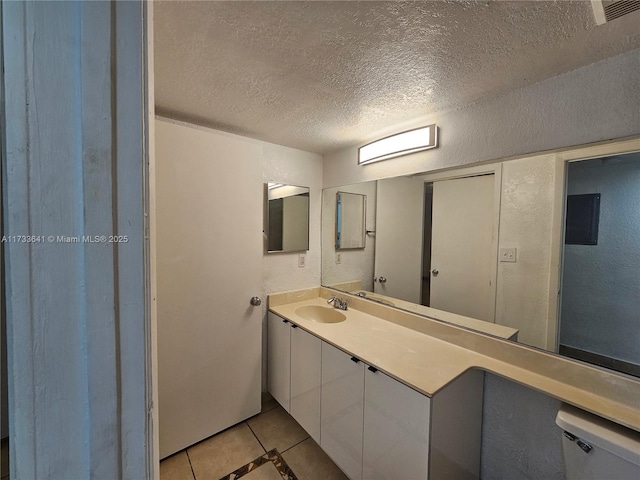 bathroom with vanity, tile patterned floors, a textured ceiling, and toilet