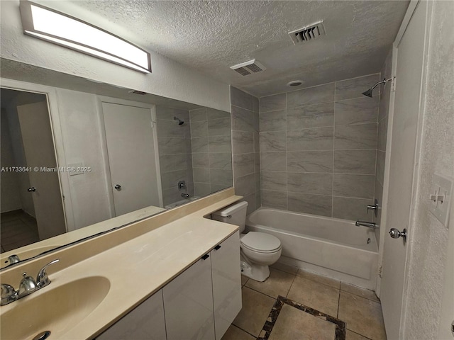 full bathroom with tile patterned floors, toilet, a textured ceiling, vanity, and tiled shower / bath combo