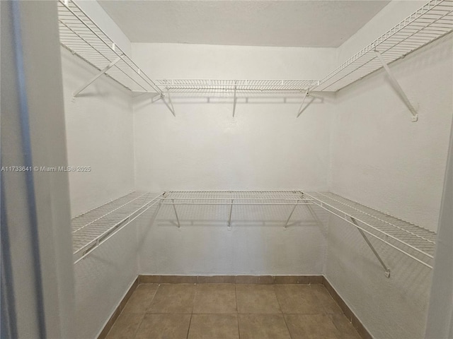 walk in closet with tile patterned floors