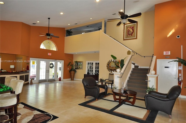 interior space with a towering ceiling, french doors, and ceiling fan